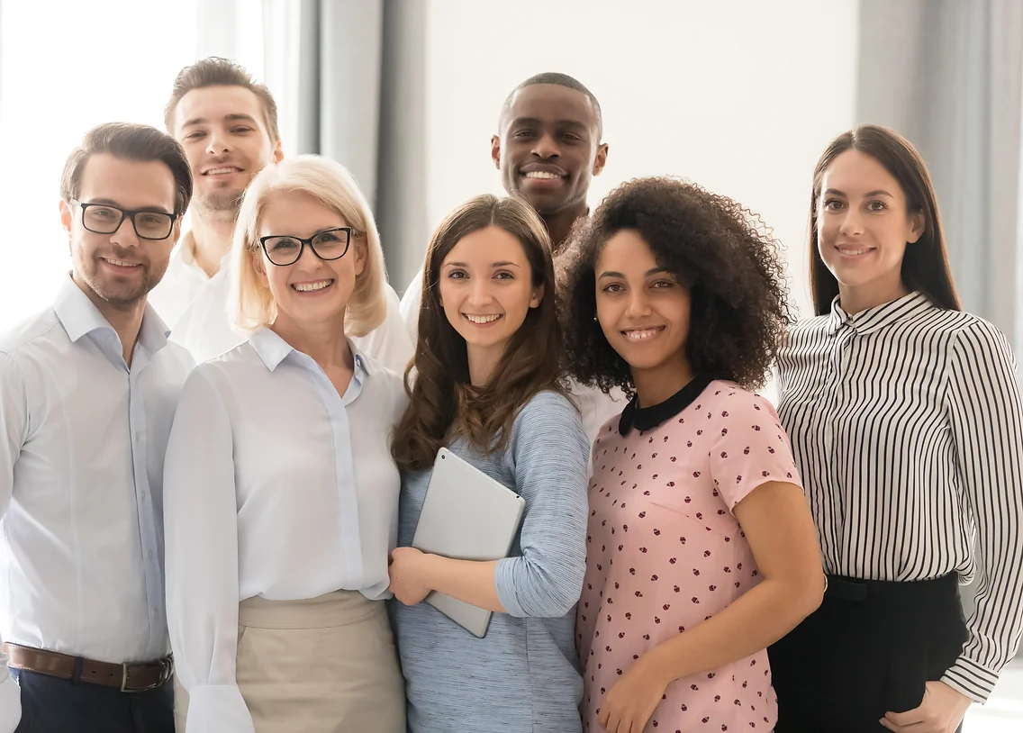 Multiethnic smiling businesspeople standing looking at camera making group photo in office